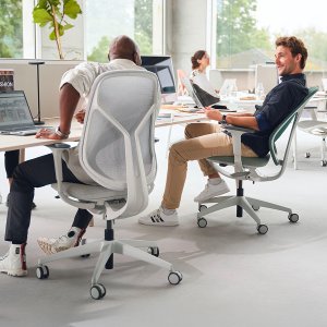 Työpistetuolit se:kit salvianvihreällä verhoillulla selkänojalla kuuden hengen bench-pöydän ympärillä